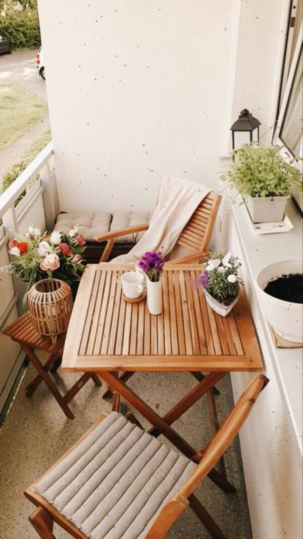 Cozy balcony with plants, chair, and small table